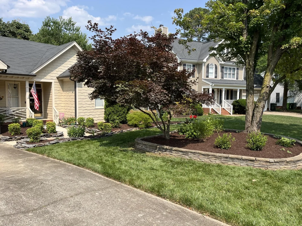 Well-maintained front yard with lush grass and landscaped garden beds.